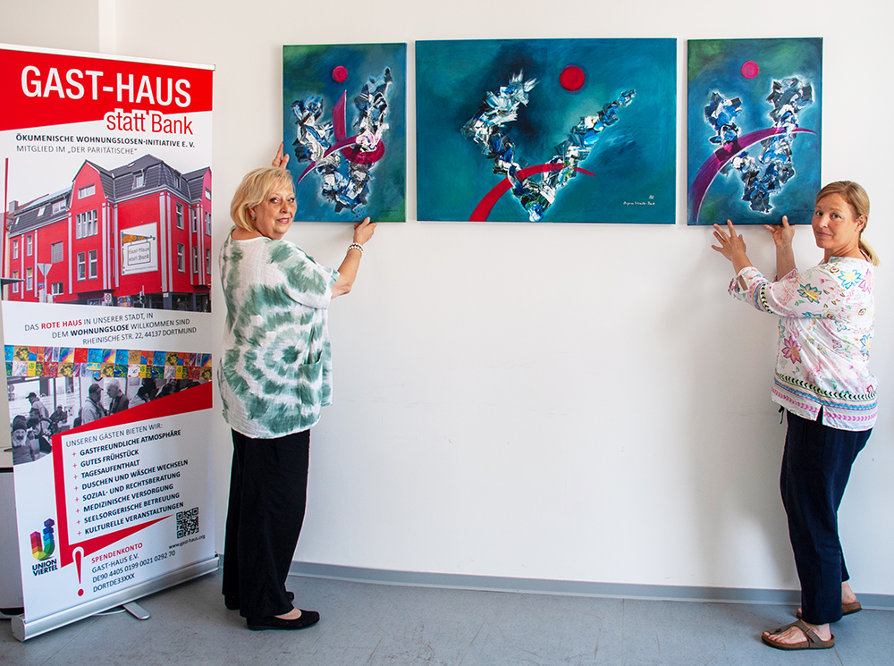 Bei der Probehängung des neuen Bildes: links Dagmar Schnecke-Bend (Künstlerin) und rechts Katrin Lauterborn (Geschäftsführerin Gast-Haus e.V.), Foto: Rüdiger Beck